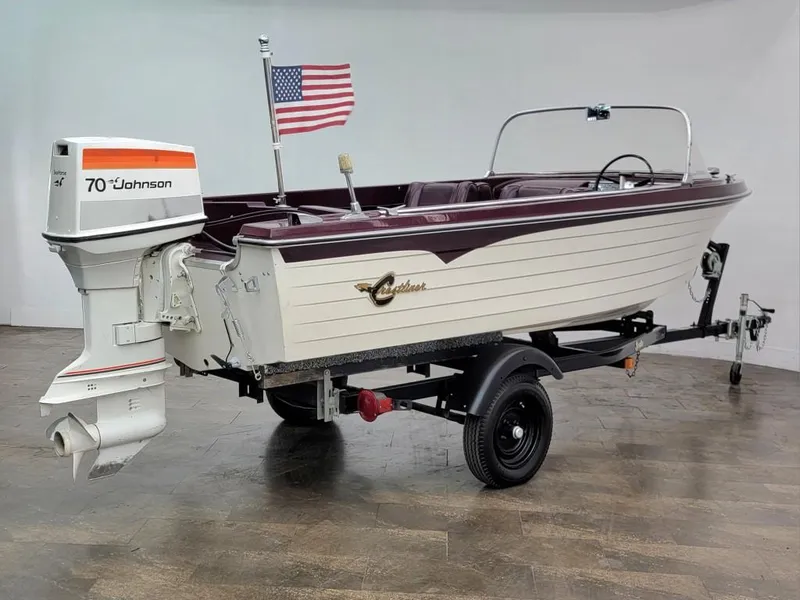 Slide: The Image of 1969 Crestliner Marauder boat with 70 HP Johnson outboard motor and American flag. - 16