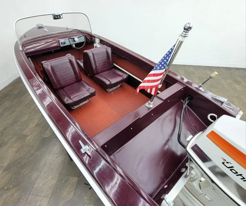 Slide: The Image of 1969 Crestliner Marauder boat with maroon interior and American flag. - 23
