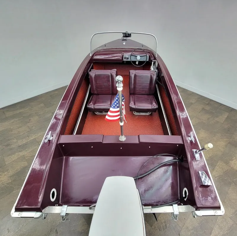 Slide: The Image of 1969 Crestliner Marauder boat with maroon interior and American flag. - 24