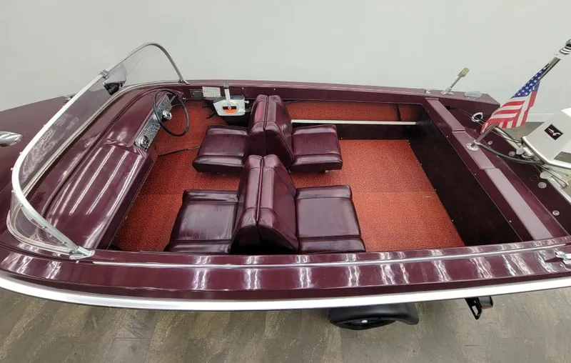 Slide: The Image of 1969 Crestliner Marauder boat with maroon interior and American flag. - 26