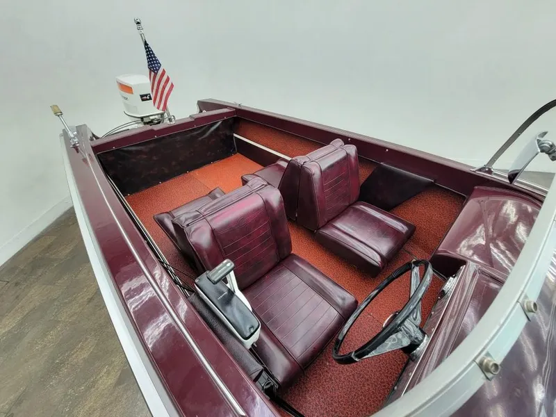 Slide: The Image of 1969 Crestliner Marauder boat with maroon interior and American flag. - 37