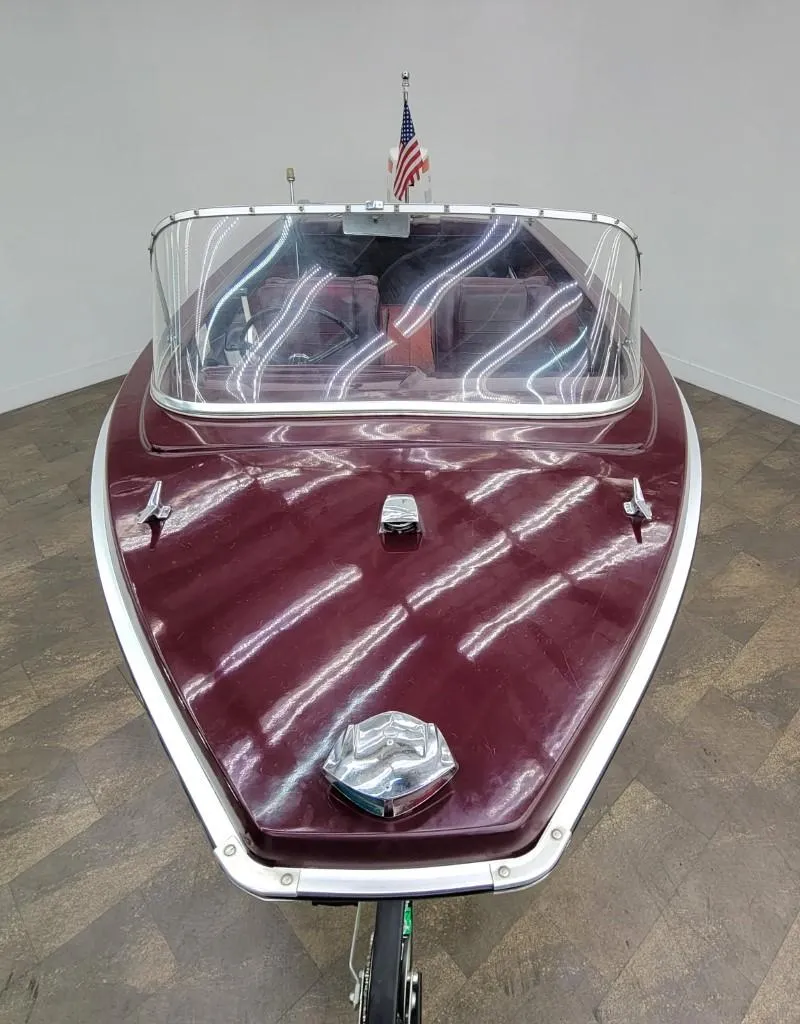 Slide: The Image of 1969 Crestliner Marauder boat with maroon hull and American flag. - 8