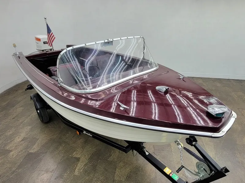 Slide: The Image of 1969 Crestliner Marauder boat with maroon and white exterior on trailer. - 9