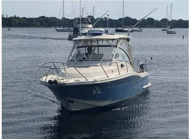 Slide: The Image of 2014 Scout 262 Abaco boat cruising on a calm lake with other boats in the background. - 2