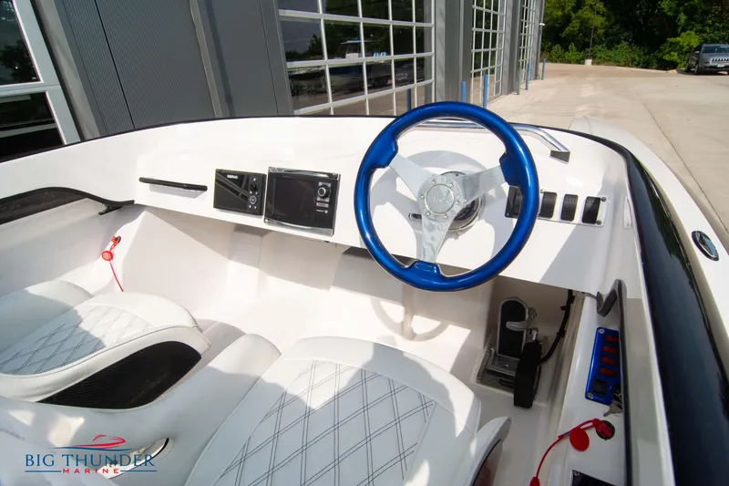 Slide: The Image of 2019 Spectre Screaming Eagle 22 Talon boat interior with blue steering wheel and white seats. - 26