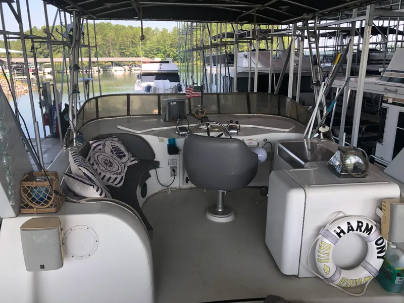 Slide: The Image of 1990 Bluewater Sedan boat interior with helm, seating, and lake view. - 12