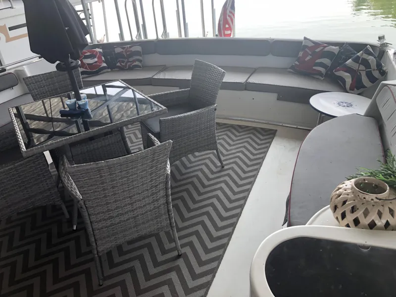 Slide: The Image of Outdoor seating area on a 1990 Bluewater Sedan boat with wicker furniture and patterned cushions. - 14