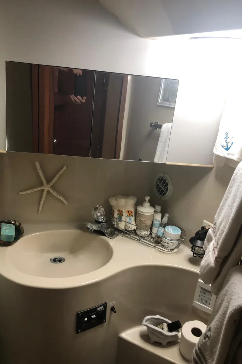 Slide: The Image of 1990 Bluewater Sedan bathroom with sink, mirror, and toiletries. - 31
