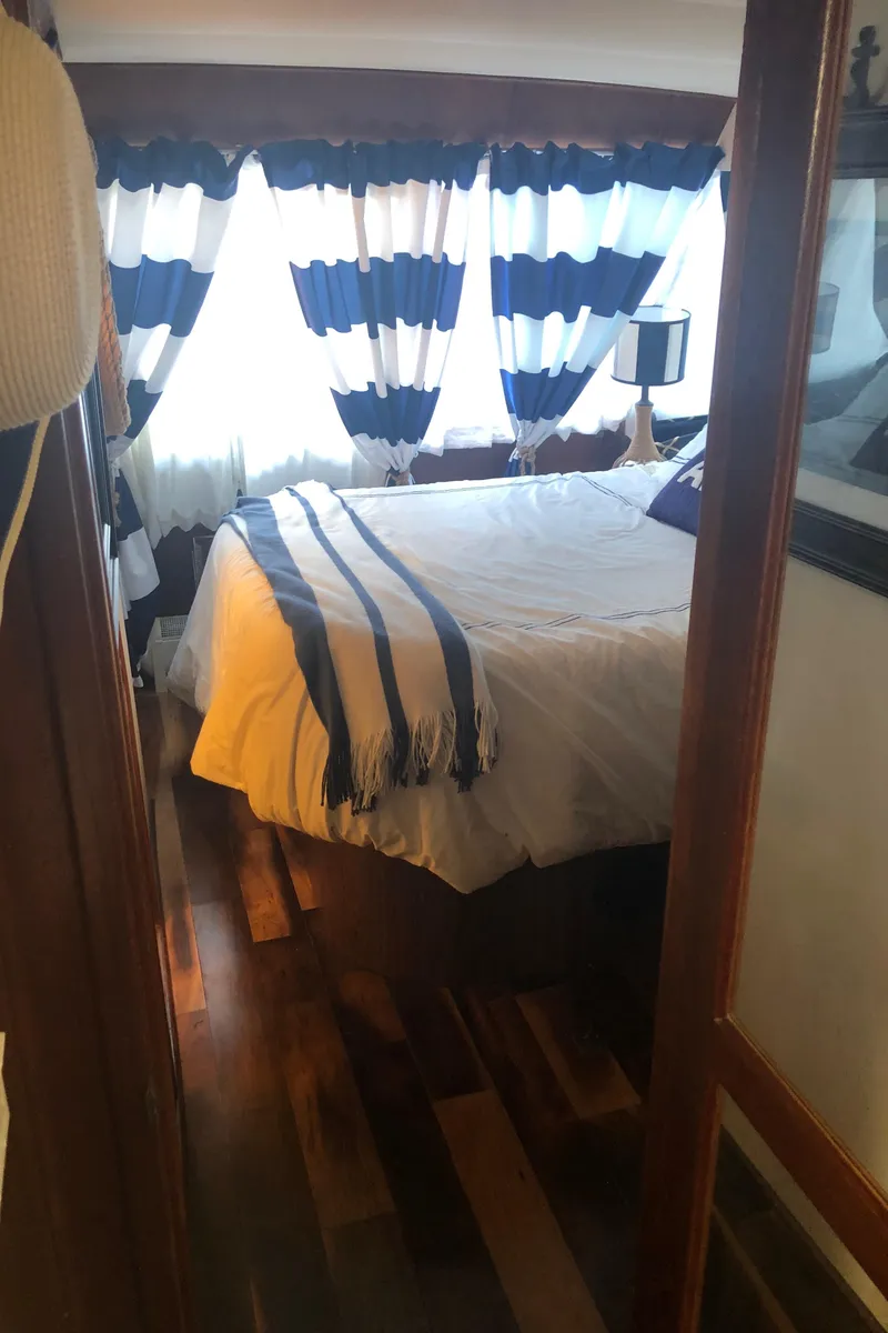 Slide: The Image of 1990 Bluewater Sedan bedroom with striped curtains and wooden flooring. - 36