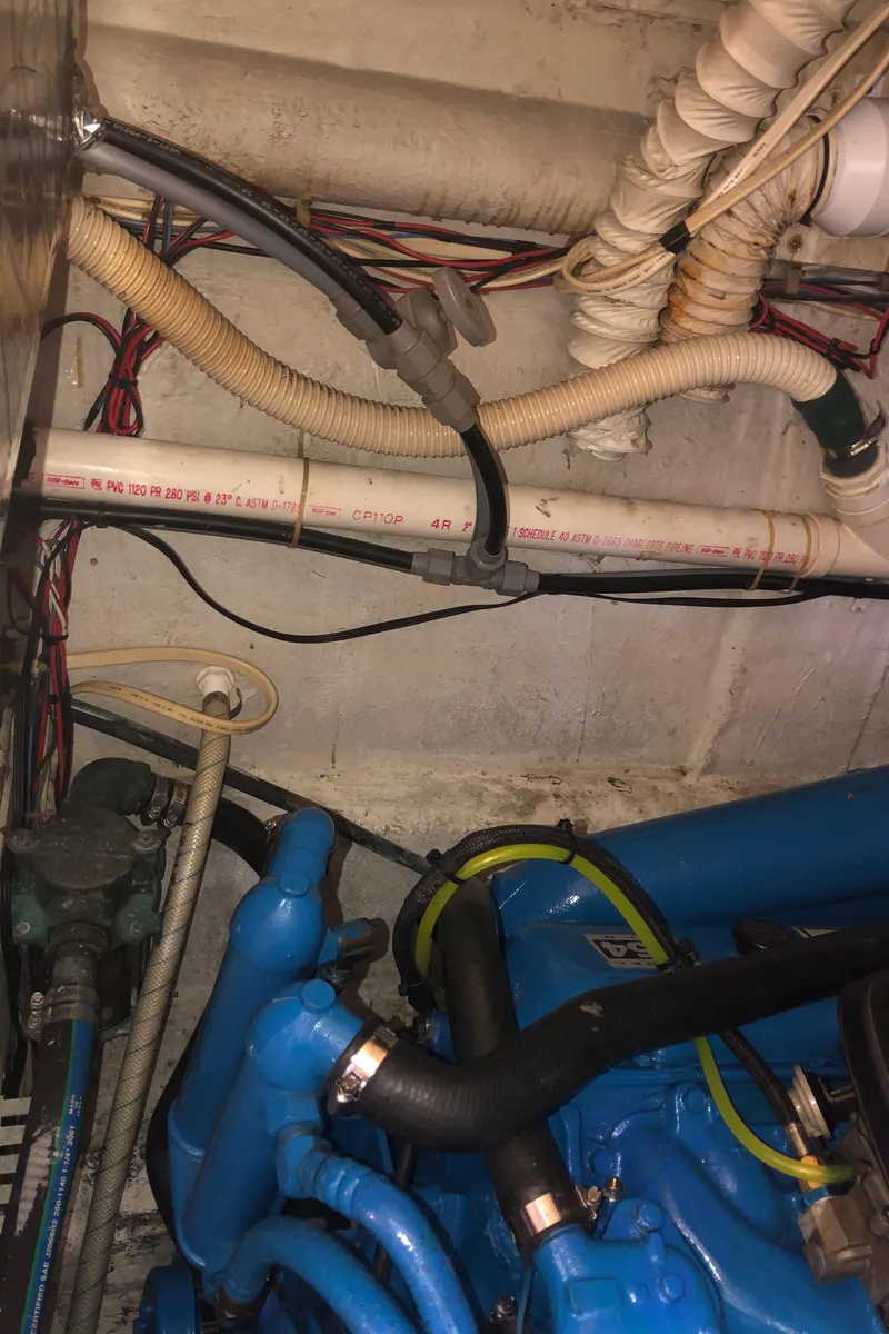 Slide: The Image of Engine compartment of a 1990 Bluewater Sedan with visible wiring and hoses. - 43