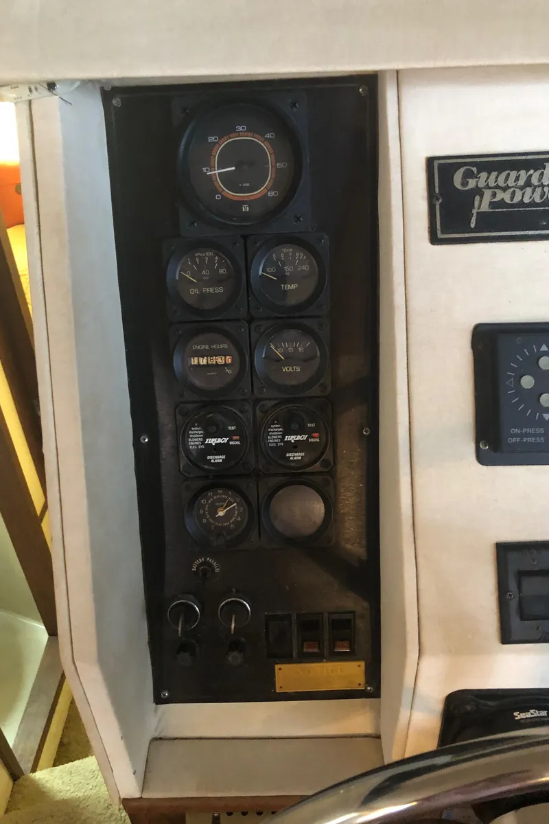 Slide: The Image of Control panel of a 1990 Bluewater Sedan boat with various gauges and switches. - 46