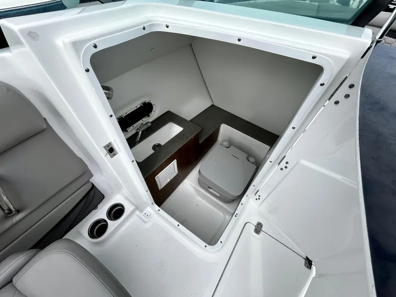 Slide: The Image of 2022 Four Winns HD5 OB boat interior with compact bathroom and sink. - 11