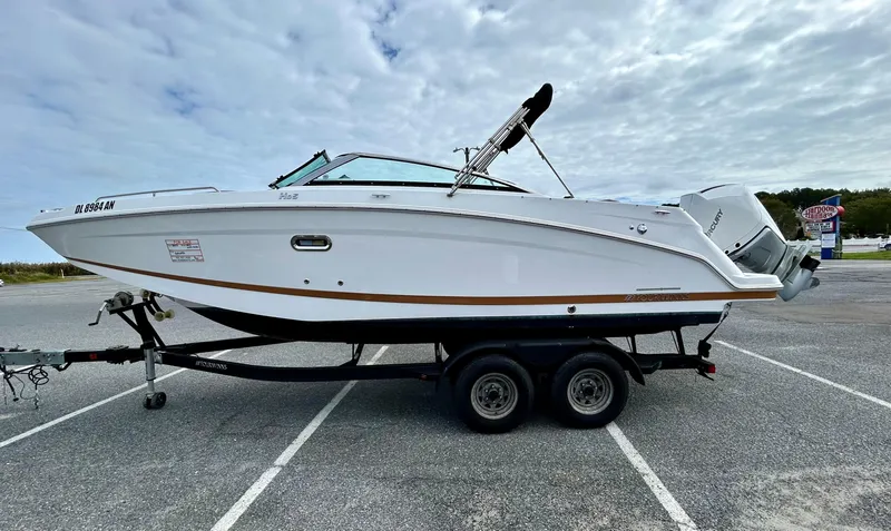 Slide: The Image of 2022 Four Winns HD5 OB boat on trailer in parking lot under cloudy sky. - 2