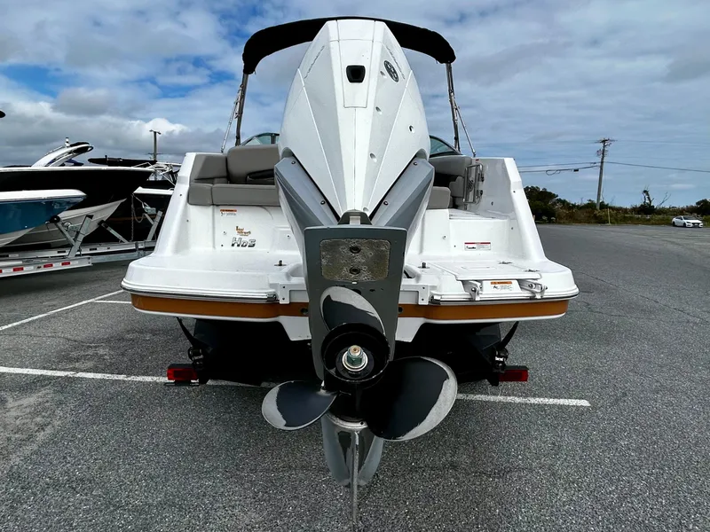 Slide: The Image of 2022 Four Winns HD5 OB boat, rear view, parked on asphalt under cloudy sky. - 6