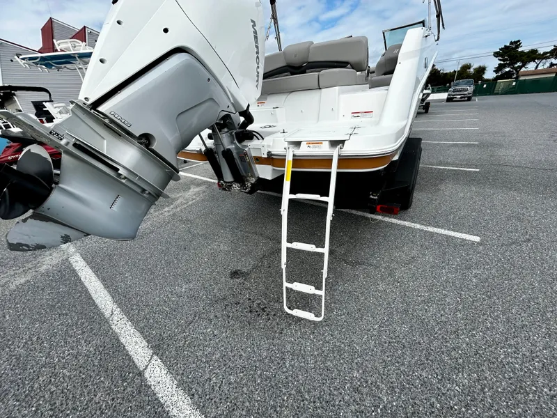 Slide: The Image of 2022 Four Winns HD5 OB boat with outboard motor and boarding ladder in parking lot. - 7