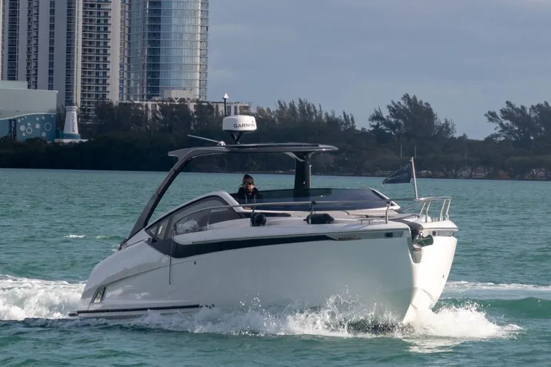 Slide: The Image of 2023 Fairline F//Line 33 Outboard cruising on water near cityscape. - 0