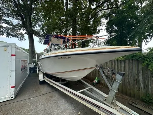Slide: The Image of 2002 Fountain 25 C/C boat on trailer, surrounded by trees. - 1