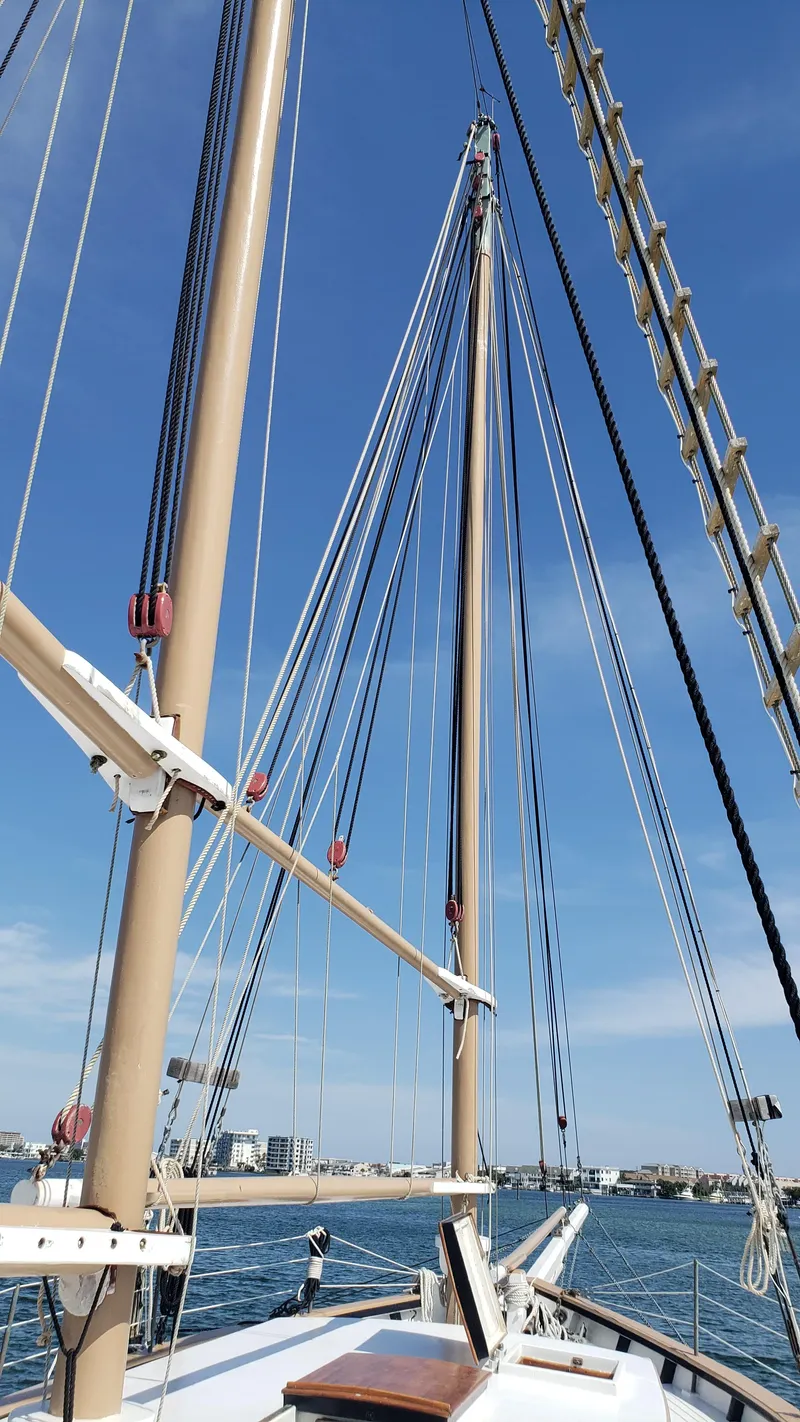 Slide: The Image of Alt text: 1996 Custom Biloxi Schooner mast and rigging against blue sky. - 11