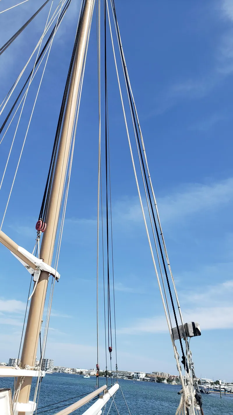 Slide: The Image of Mast and rigging of a 1996 Custom Biloxi Schooner against a clear blue sky. - 13