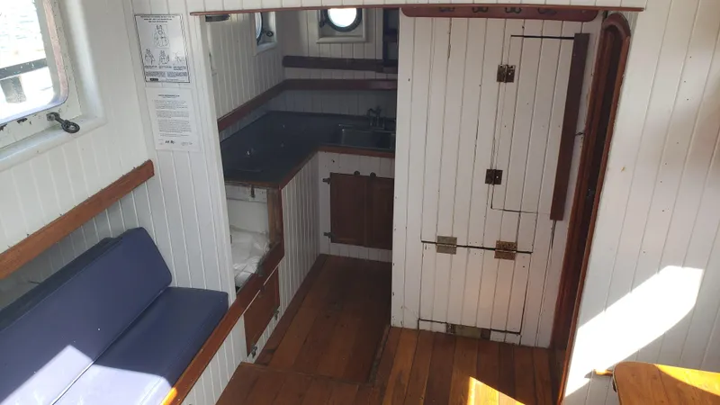 Slide: The Image of Interior of 1996 Custom Biloxi Schooner with wooden floors and compact kitchen. - 23