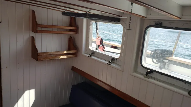 Slide: The Image of Interior of 1996 Custom Biloxi Schooner with wooden shelves and ocean view through windows. - 24