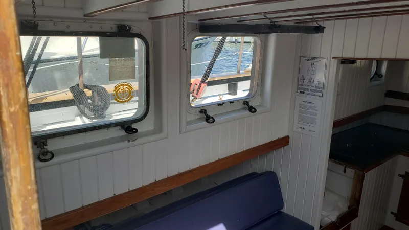 Slide: The Image of Interior of a 1996 Custom Biloxi Schooner with white paneling and blue seating. - 25