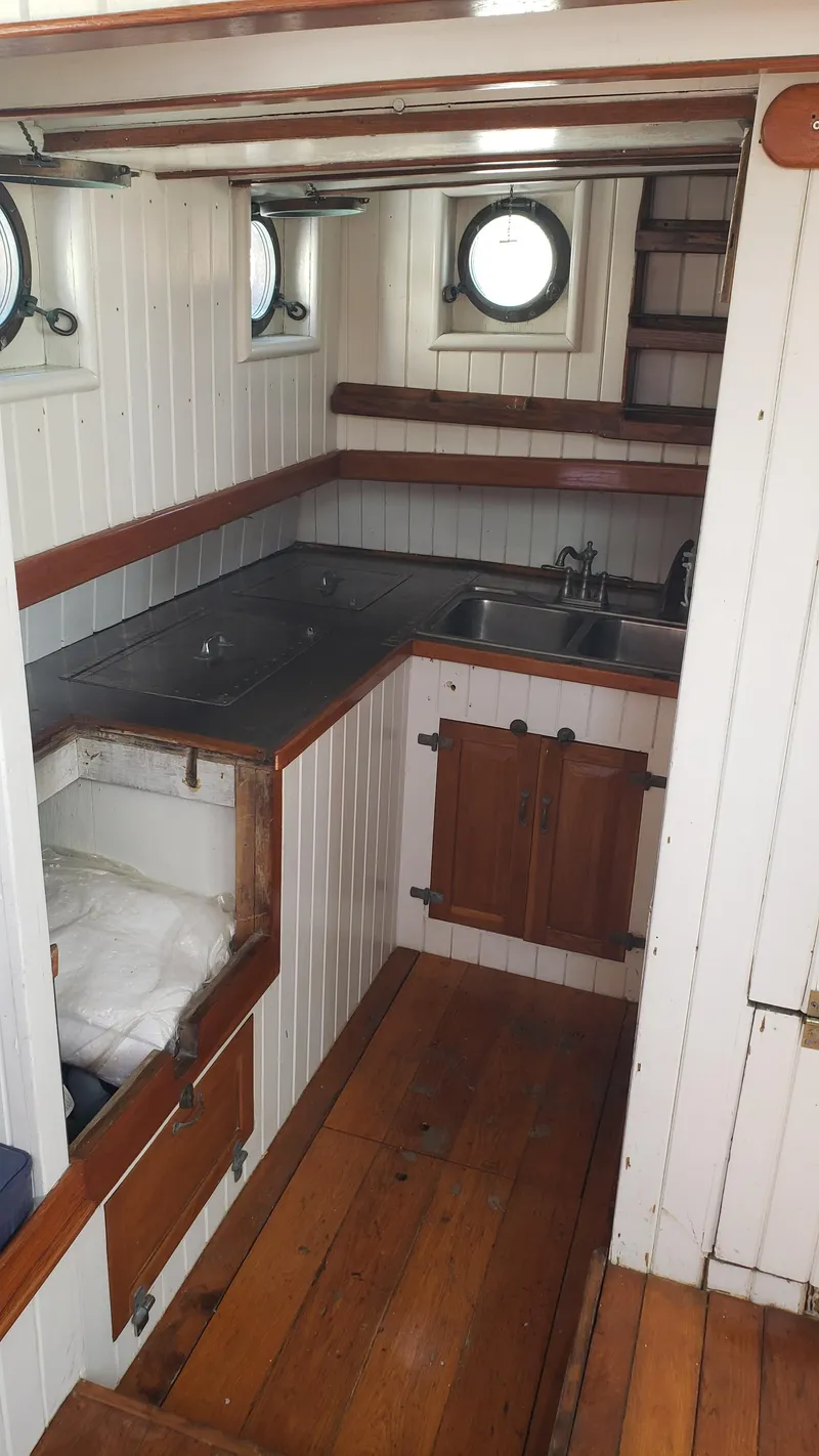 Slide: The Image of 1996 Custom Biloxi Schooner interior with wooden cabinetry and porthole windows. - 26