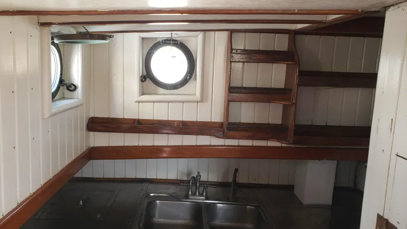 Slide: The Image of Interior of a 1996 Custom Biloxi Schooner with wooden stairs and porthole windows. - 27