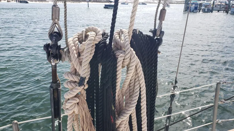 Slide: The Image of Coiled ropes on a 1996 Custom Biloxi Schooner docked by the water. - 34