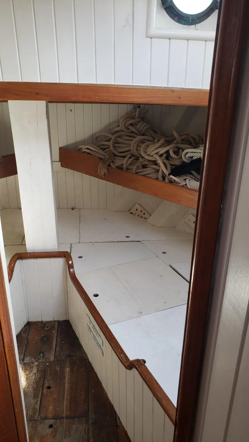 Slide: The Image of Interior of 1996 Custom Biloxi Schooner with wooden shelves and coiled ropes. - 41