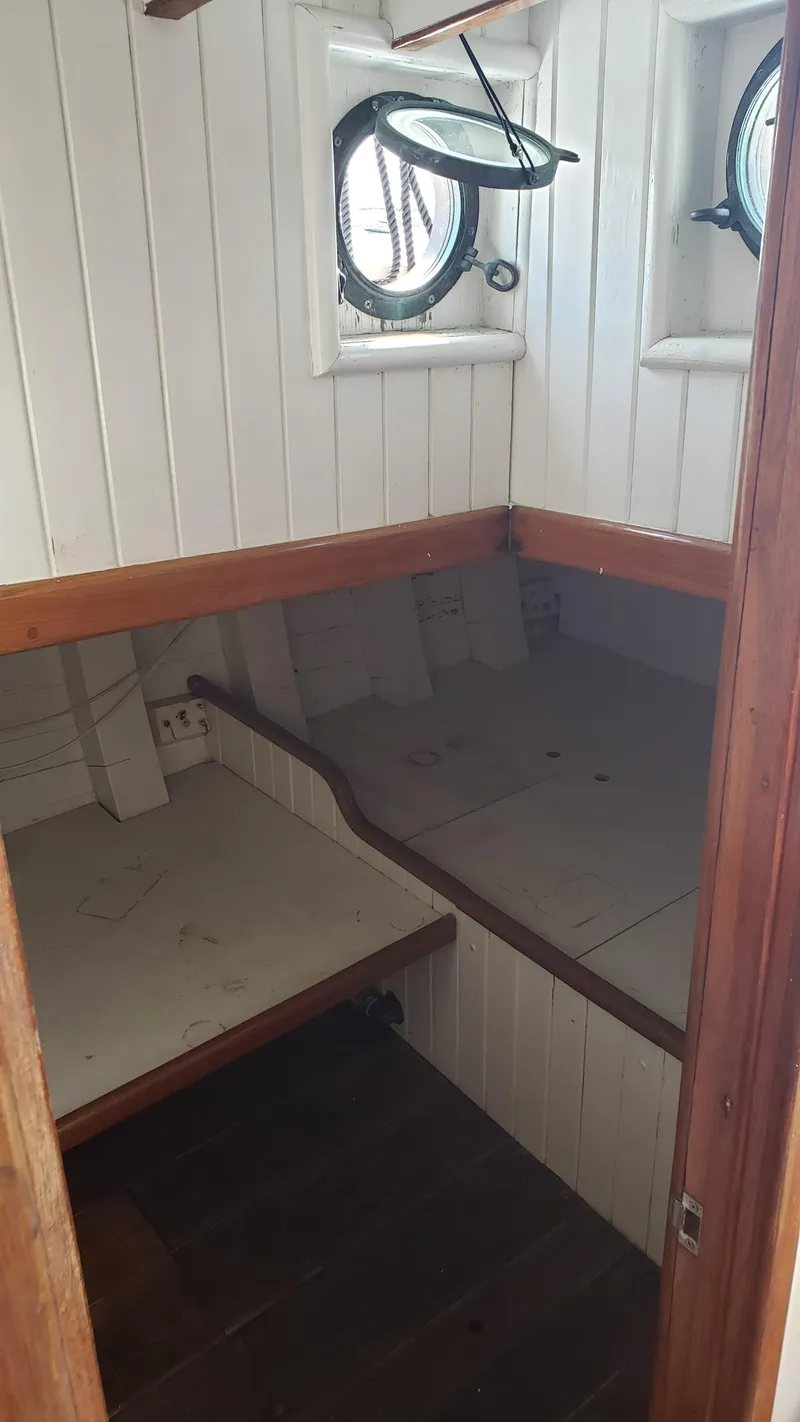 Slide: The Image of Interior cabin of 1996 Custom Biloxi Schooner with wooden paneling and porthole windows. - 47