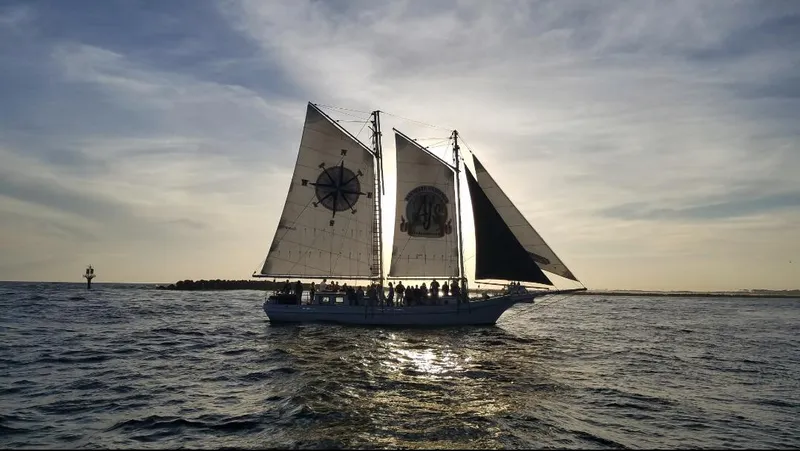 Slide: The Image of Alt text: 1996 Custom Biloxi Schooner sailing at sunset on open water. - 5