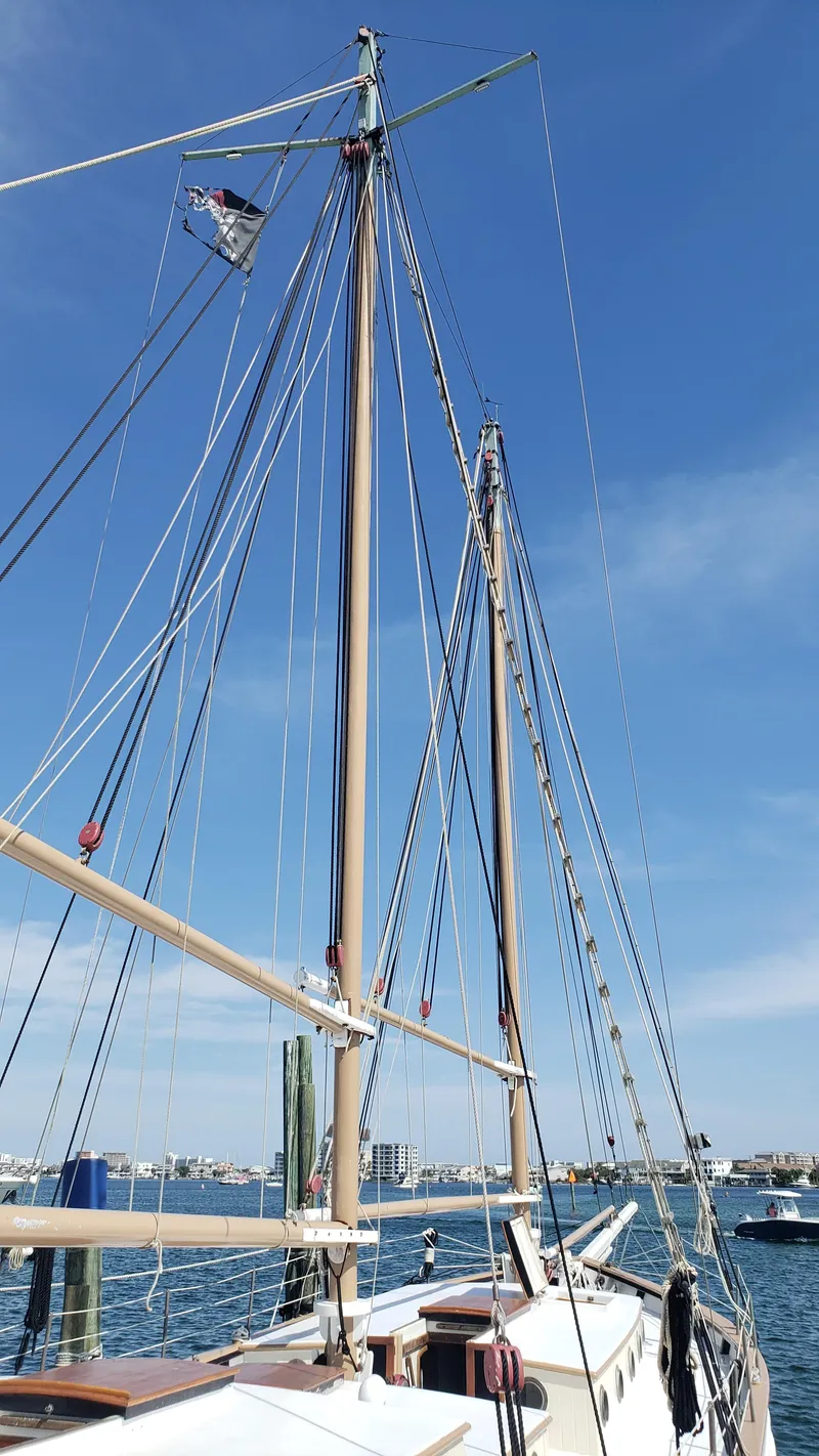 Slide: The Image of Alt text: 1996 Custom Biloxi Schooner docked with tall masts against blue sky. - 9