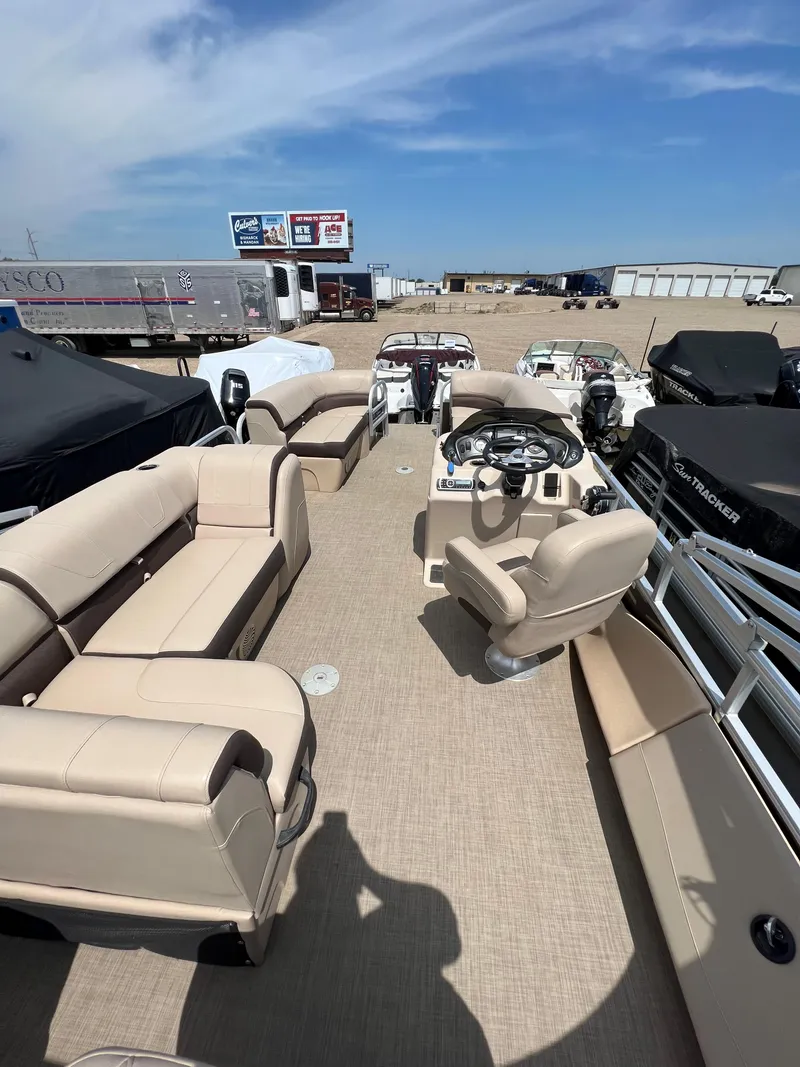 Slide: The Image of 2018 Sun Tracker SportFish 22 XP3 pontoon boat with beige seating and steering console. - 12