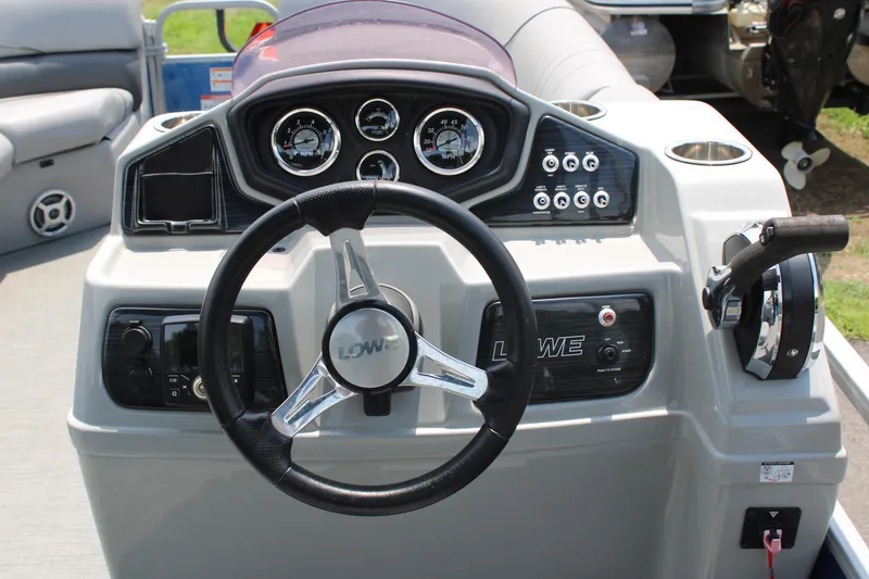 Slide: The Image of 2021 Lowe SS250 Super Sport boat dashboard with steering wheel and control panel. - 10