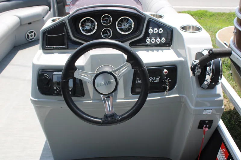 Slide: The Image of 2021 Lowe SS250 Super Sport boat dashboard with steering wheel and control panel. - 6