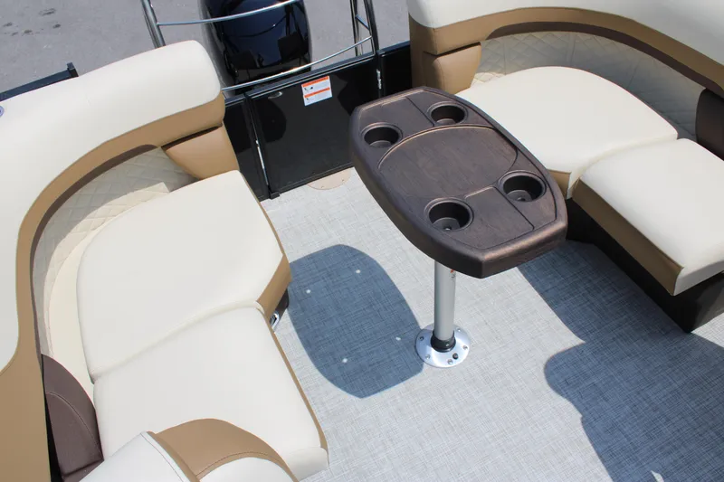 Slide: The Image of 2023 Lowe SS210 Super Sport boat interior with beige seating and central table. - 8