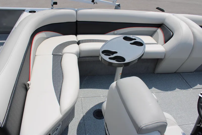 Slide: The Image of 2023 Lowe SD224 Sport Deck boat interior with cushioned seating and cup holder table. - 12