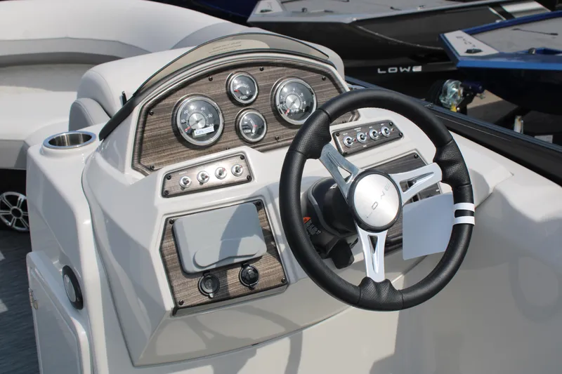 Slide: The Image of 2023 Lowe SS210 Super Sport boat dashboard with steering wheel and gauges. - 12