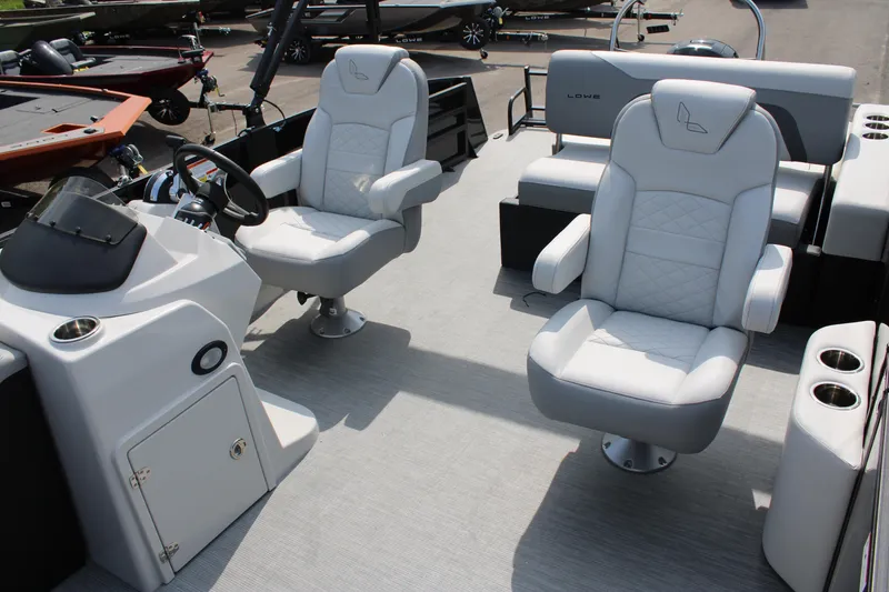 Slide: The Image of 2023 Lowe SS210 Super Sport boat interior with plush seating and modern helm. - 9