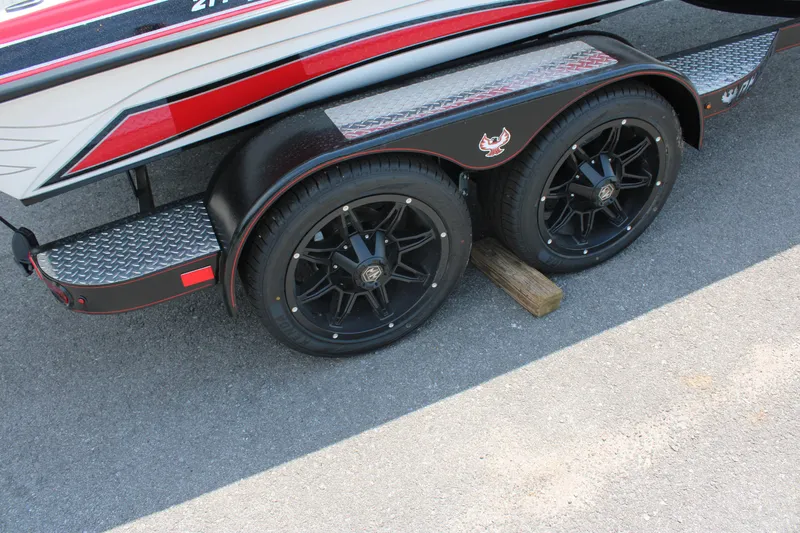Slide: The Image of 2024 Phoenix 21 PHX boat trailer with black alloy wheels and red accents. - 8