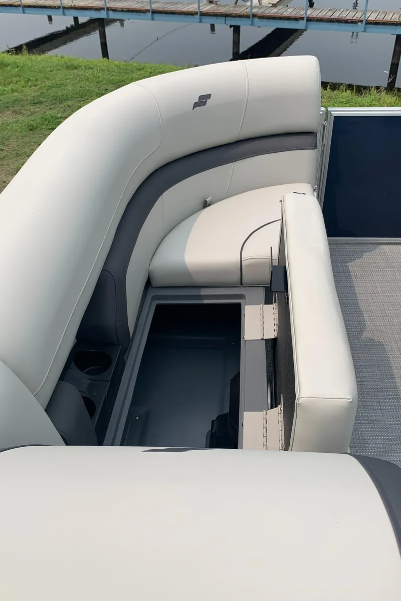 Slide: The Image of 2023 Starcraft EX 24 R pontoon boat with open storage compartment and cushioned seating. - 12