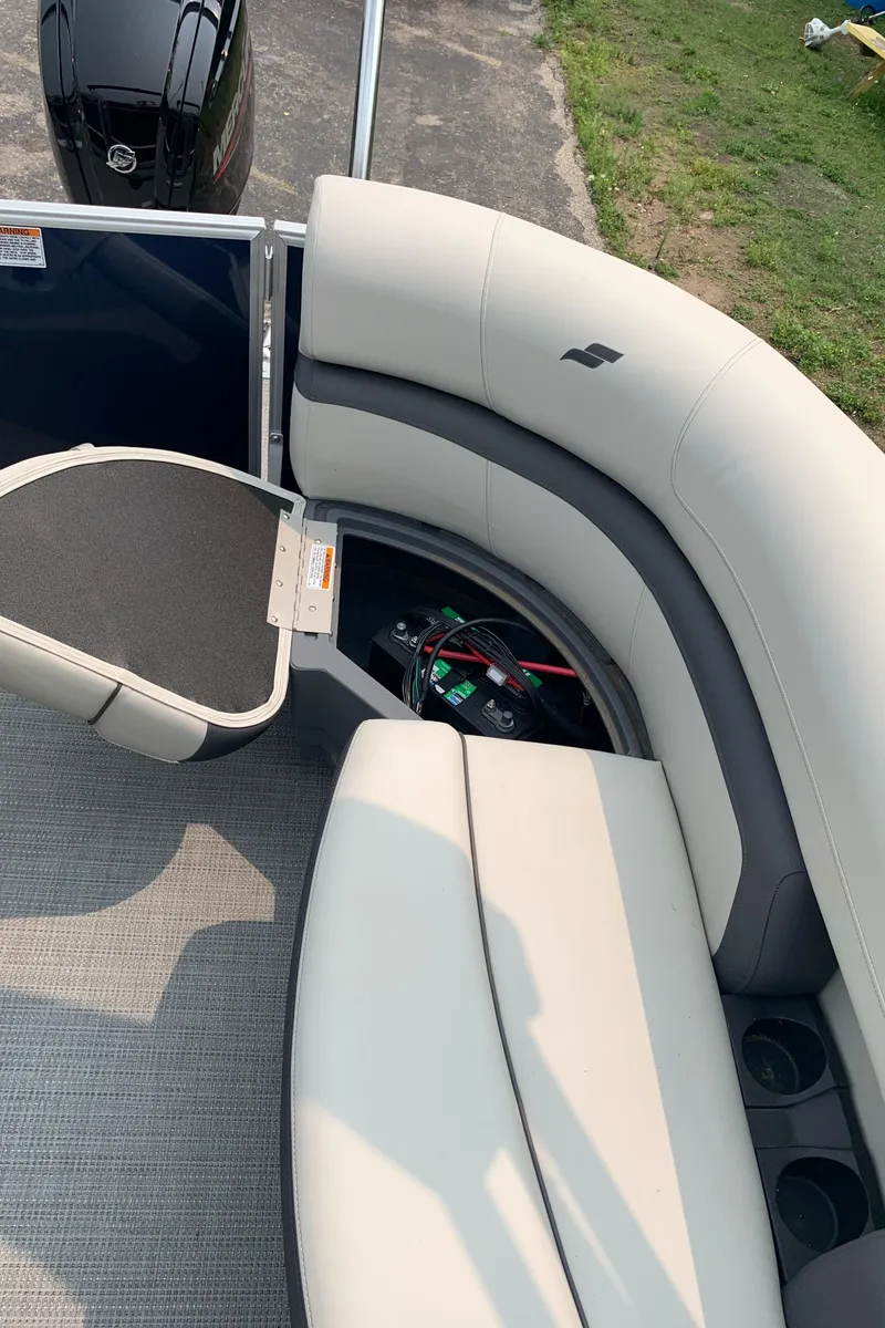 Slide: The Image of 2023 Starcraft EX 24 R pontoon boat interior with plush seating and storage. - 14