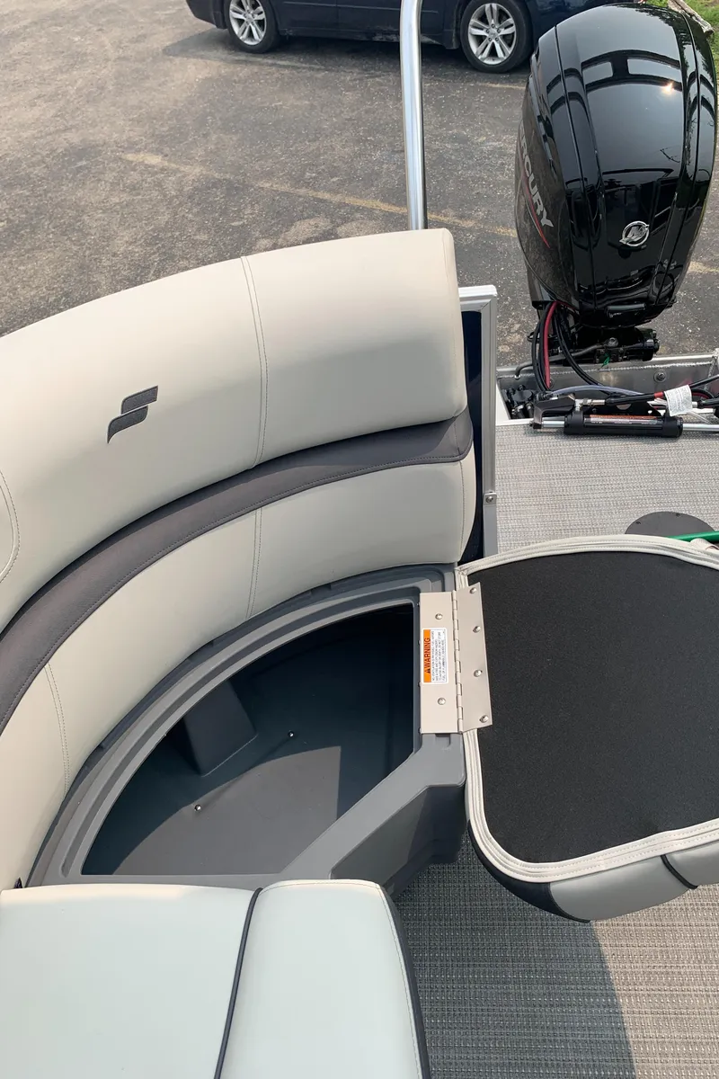 Slide: The Image of 2023 Starcraft EX 24 R pontoon boat with open storage compartment and outboard motor. - 6