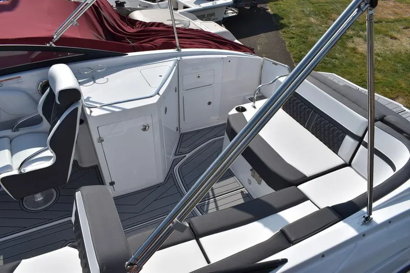 Slide: The Image of 2024 Monterey M6 boat interior with white and black seating, helm, and storage compartments. - 16