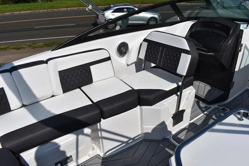 Slide: The Image of 2024 Monterey M6 boat interior with black and white seating, dashboard, and road in background. - 33