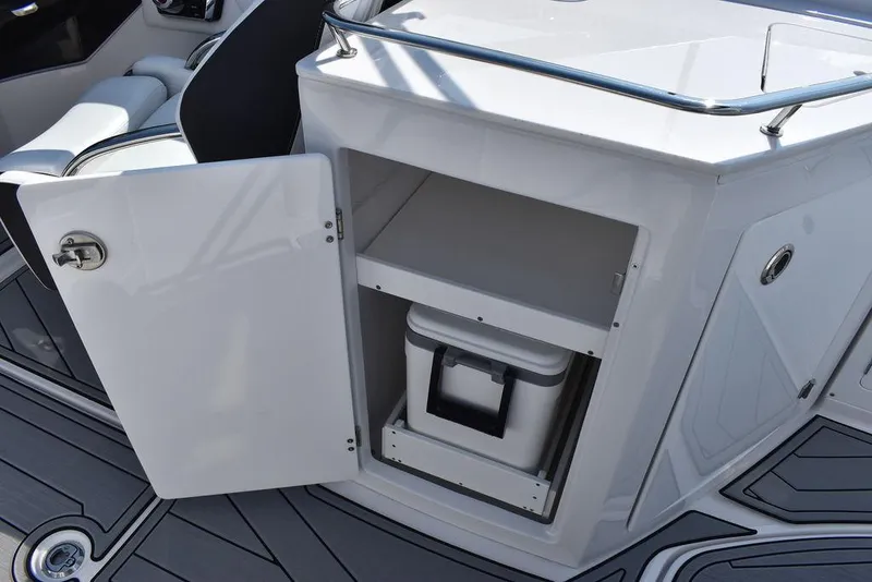 Slide: The Image of 2024 Monterey M6 boat interior storage compartment with open door and cooler. - 38
