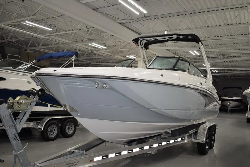 Slide: The Image of 2024 Monterey M-65 boat on a trailer in a showroom. - 2