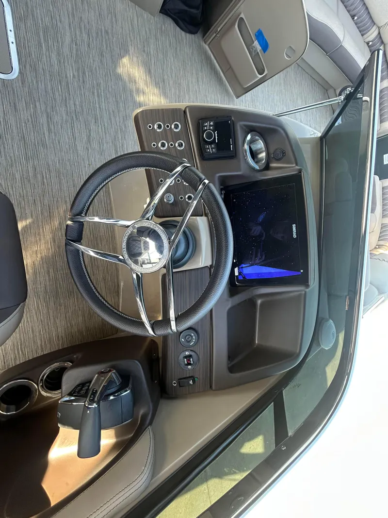 Slide: The Image of 2023 Bennington 28 QXSBW boat dashboard with steering wheel and control panel. - 7
