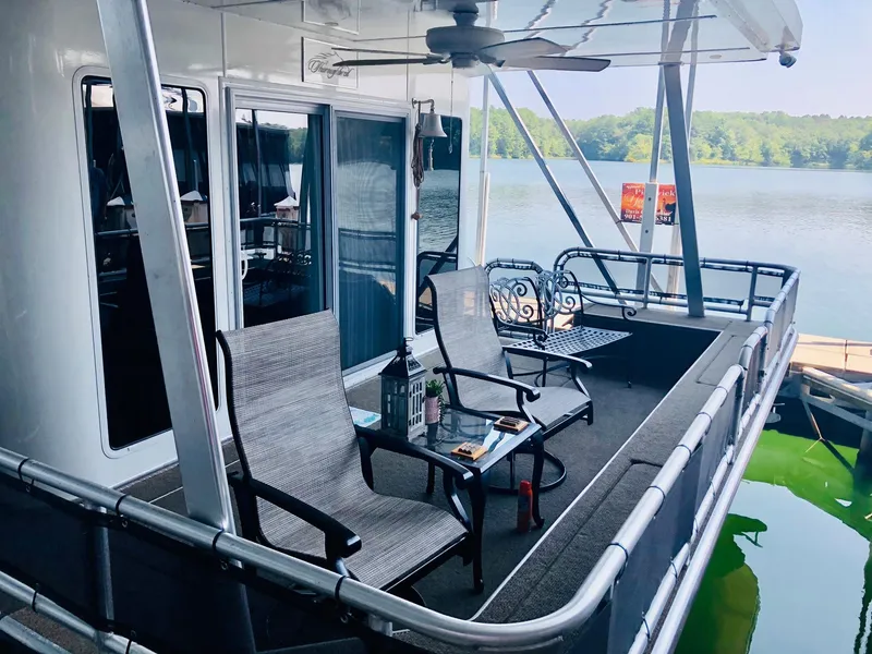 Slide: The Image of Thoroughbred 67x17 2016 houseboat with outdoor seating on a serene lake. - 15